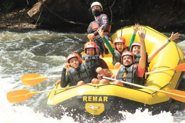 bote-de-rafting-descendo-a-corredeira-com-pessoas-vibrando