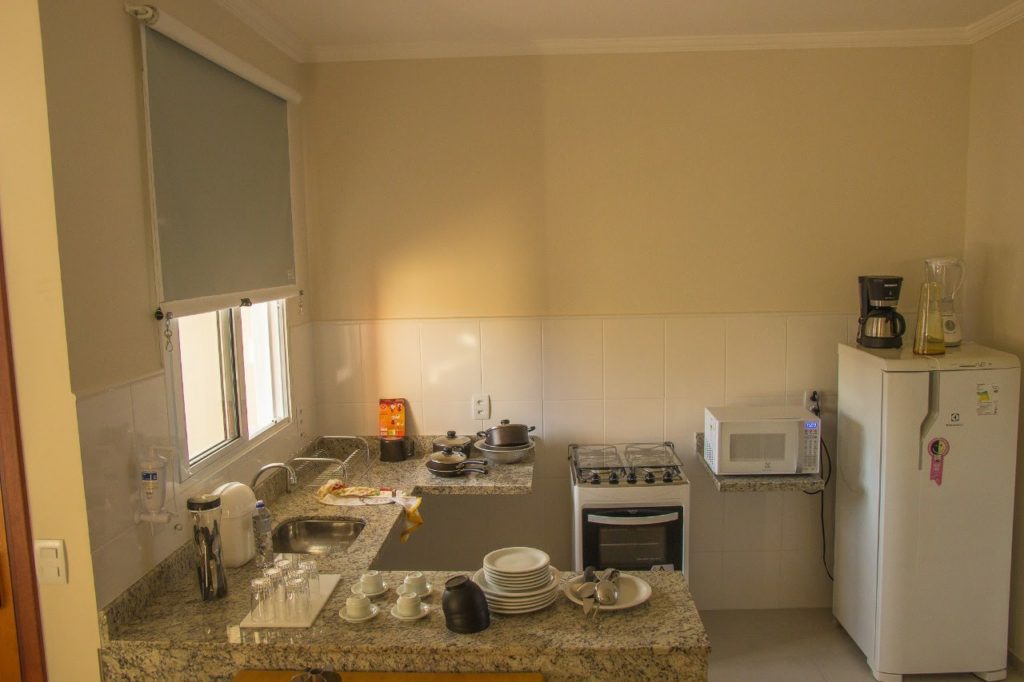 Cozinha equipada com geladeira, fogão e microondas.