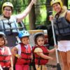 duas-mulheres-e-três-crianças-equipadas-de-colete e-capacete-para-o-mini-rafting