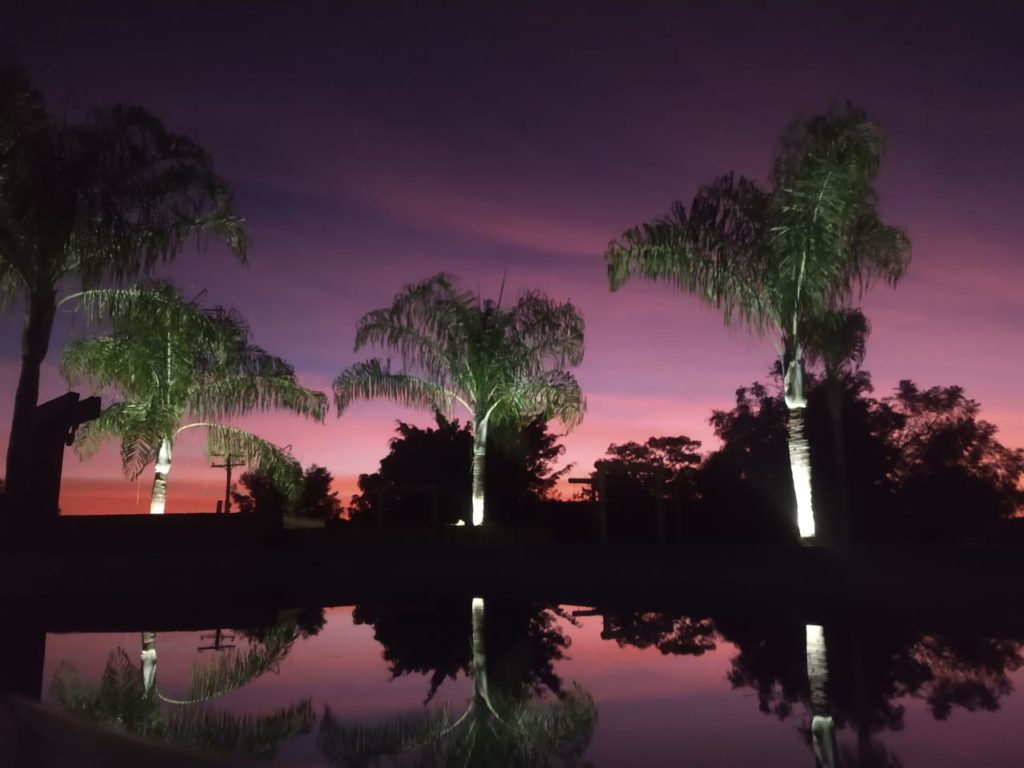 foto-noturna-da-piscina-espelhando-o-céu-muiticolorido-de-Brotas